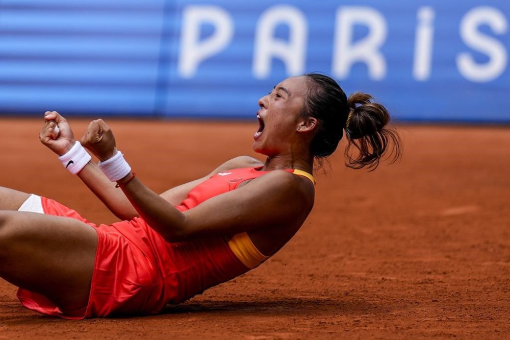 Qinwen Zheng of China celebrates her victory over Iga Swiatek of Poland during their women's semifinals match at the Roland Garros stadium, at the 2024 Summer Olympics, Thursday, Aug. 1, 2024, in Paris, France. (AP Photo/Manu Fernandez)