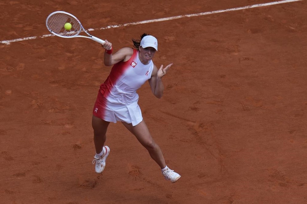 Iga Swiatek of Poland returns a shot to Zheng Qinwen of China during their women's semifinals match, at the 2024 Summer Olympics, Thursday, Aug.1, 2024, at the Roland Garros stadium in Paris, France. (AP Photo/Andy Wong)