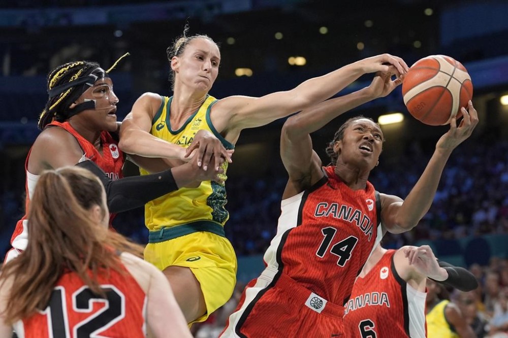 Canada's Aaliyah Edwards, left, and Kayla Alexander, right, reach for a rebound along with Australia's Steph Talbot during a women's basketball game at the 2024 Summer Olympics, Thursday, Aug. 1, 2024, in Villeneuve-d'Ascq, France. THE CANADIAN PRESS/AP/Michael Conroy