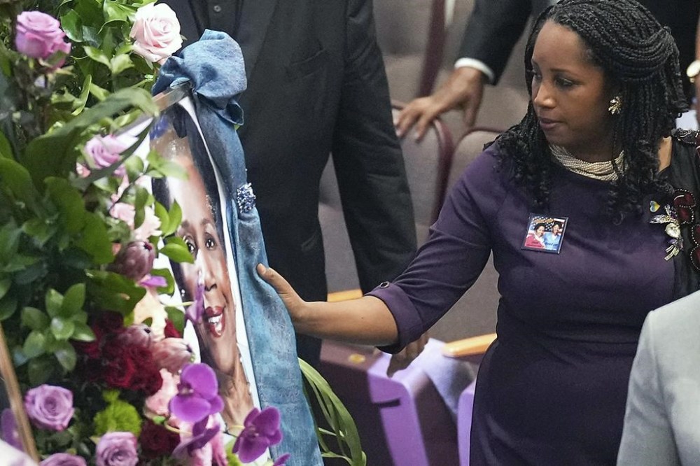 Erica Lee touches the scarf adorning a portrait of her mother, the late Congresswoman Sheila Jackson Lee at God's Grace Community Church on Tuesday, July 30, 2024 in Houston. (Elizabeth Conley/Houston Chronicle via AP)