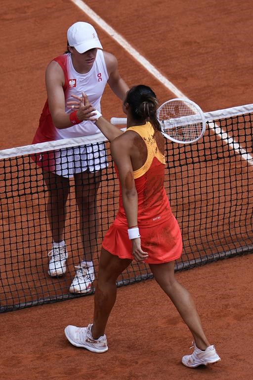 Zheng Qinwen of China is congratulated by Iga Swiatek of Poland after winning in their women's semifinals match, at the 2024 Summer Olympics, Thursday, Aug.1, 2024, at the Roland Garros stadium in Paris, France. (AP Photo/Andy Wong)