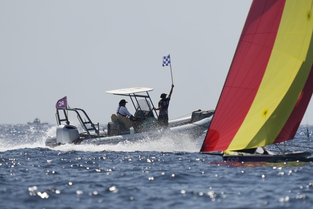 A race officer waves the flag and cancel the men's skiff race due to wind, during the 2024 Summer Olympics, Thursday, Aug. 1, 2024, in Marseille, France. (AP Photo/Carolyn Kaster)