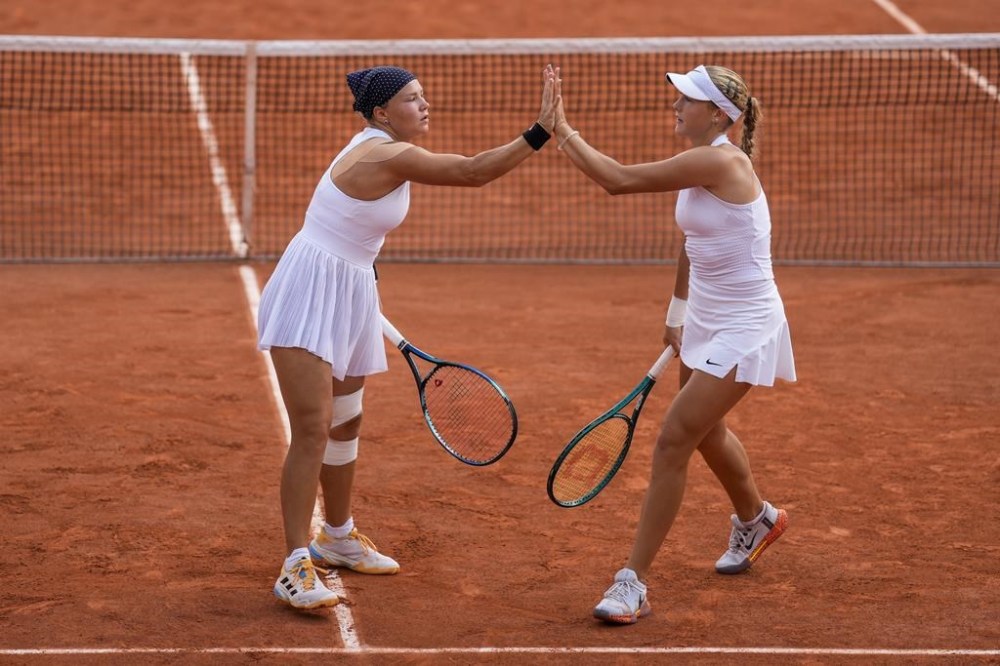 Mirra Andreeva, right, and her teammate Diana Shnaider of Individual Neutral Athlete celebrates a point against Barbora Krejcikov and Katerina Siniakova of Czech Republic during their women's doubles quarter-final match at the Roland Garros stadium, at the 2024 Summer Olympics, Thursday, Aug. 1, 2024, in Paris, France. (AP Photo/Manu Fernandez)