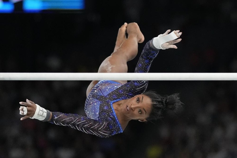 Simone Biles, of the United States, performs on the uneven bars during the women's artistic gymnastics all-around finals in Bercy Arena at the 2024 Summer Olympics, Thursday, Aug. 1, 2024, in Paris, France. (AP Photo/Natacha Pisarenko)