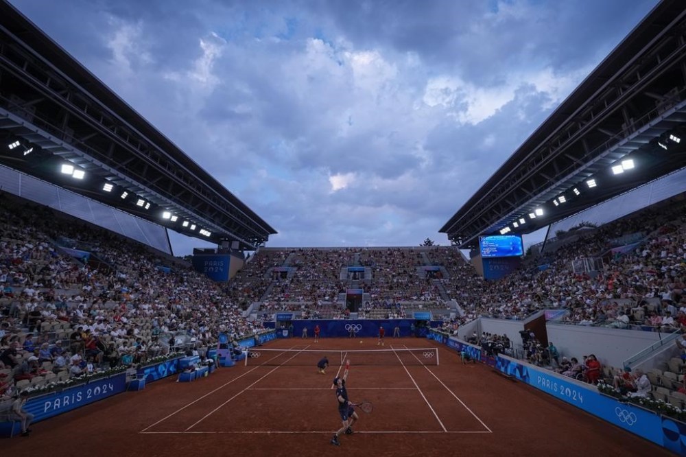 Andy Murray and Daniel Evans of Britain play against Taylor Fritz and Tommy Paul of the United States during their men's doubles quarterfinals tennis match, at the 2024 Summer Olympics, Thursday, Aug.1, 2024, at the Roland Garros stadium in Paris, France. (AP Photo/Andy Wong)