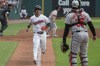 Cleveland Guardians' Steven Kwan, front left, scores on a sacrifice fly by Jose Ramirez as Baltimore Orioles' Adley Rutschman, right, stands by during the first inning of a baseball game in Cleveland, Thursday, Aug. 1, 2024. (AP Photo/Phil Long)
