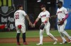 Cleveland Guardians' Josh Naylor (22) greets Lane Thomas, center, and Jhonkensy Noel, right, at the end of a baseball game against the Baltimore Orioles in Cleveland, Thursday, Aug. 1, 2024. (AP Photo/Phil Long)