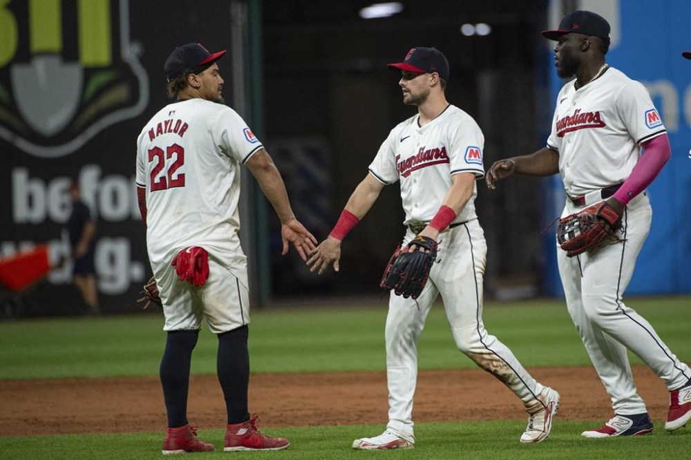 Cleveland Guardians' Josh Naylor (22) greets Lane Thomas, center, and Jhonkensy Noel, right, at the end of a baseball game against the Baltimore Orioles in Cleveland, Thursday, Aug. 1, 2024. (AP Photo/Phil Long)