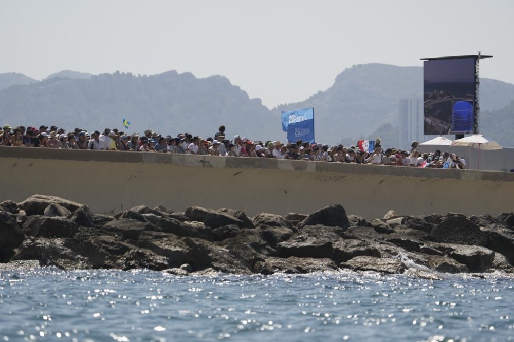 Spectators watch a women's skiff race, at the 2024 Summer Olympics, Friday, Aug. 2, 2024, in Marseille, France. (AP Photo/Jacquelyn Martin)