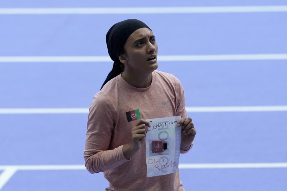 Kimia Yousofi, of Afghanistan, makes a political statement after a heat in the women's 100-meter run at the 2024 Summer Olympics, Friday, Aug. 2, 2024, in Saint-Denis, France. (AP Photo/Martin Meissner)