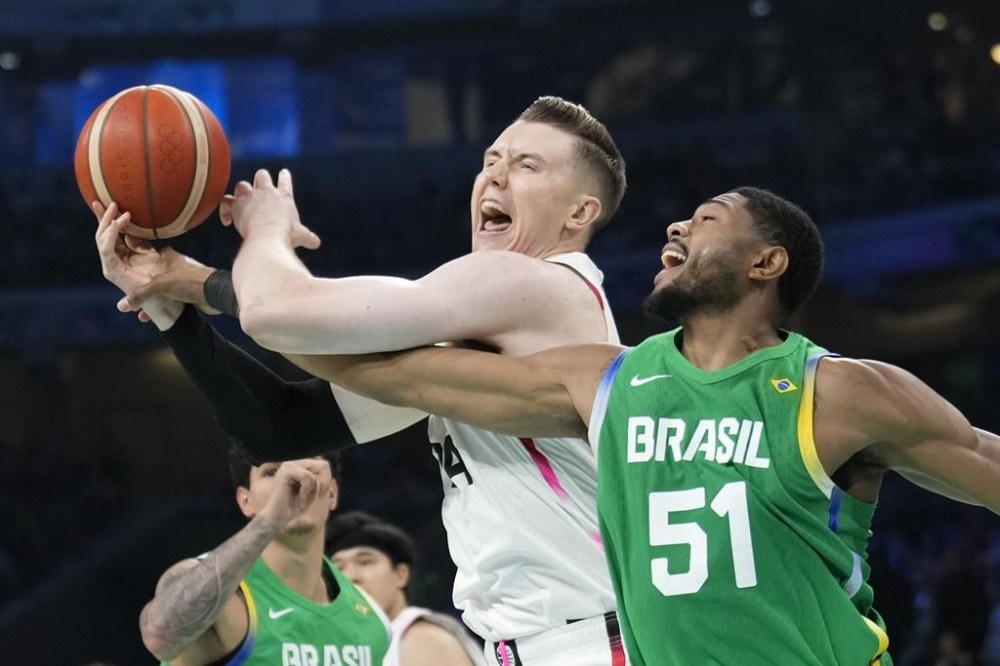Josh Hawkinson, of Japan, gets tied up with Bruno Caboclo, of Brazil, in a men's basketball game at the 2024 Summer Olympics, Friday, Aug. 2, 2024, in Villeneuve-d'Ascq, France. (AP Photo/Mark J. Terrill)