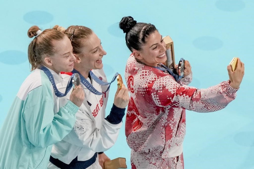 Gold medal winner Bryony Page of Britain is flanked by silver medal winner Viyaleta Bardzilouskaya of Individual Neutral Athletes, left, and bronze medal winner Sophiane Methot of Canada during the women's trampoline finals in Bercy Arena at the 2024 Summer Olympics, Friday, Aug. 2, 2024, in Paris, France. (AP Photo/Morry Gash)