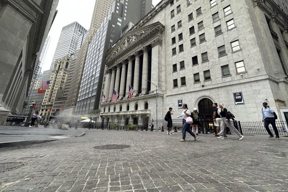 FILE - People pass the New York Stock Exchange on July 31, 2024 in New York. World shares have tumbled on Friday, August 2, 2024, with Japan's Nikkei 225 index slumping 5.8% as investors panicked over signs of weakness in the U.S. economy.(AP Photo/Peter Morgan, File)