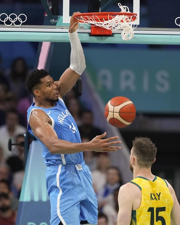 Giannis Antetokounmpo, of Greece, gets a basket on a dunk over Nick Kay, of Australia, in a men's basketball game at the 2024 Summer Olympics, Friday, Aug. 2, 2024, in Villeneuve-d'Ascq, France. (AP Photo/Mark J. Terrill)