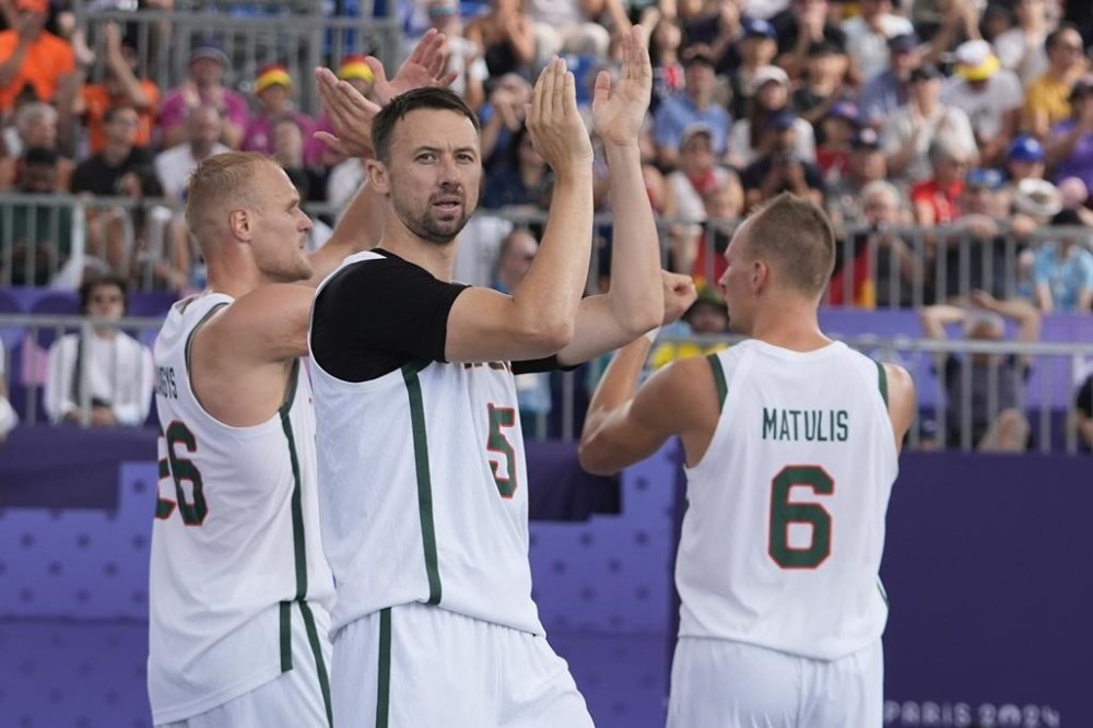 Lithuania's Sarunas Vingelis (5) joins teammats Evaldas Dziaugys (26) and Gintautas Matulis (6) as they gesture to the crowd after a men's 3x3 basketball pool round match against China during the 2024 Summer Olympics, Friday, Aug. 2, 2024, in Paris, France. Lithuania won 21-16. (AP Photo/Frank Franklin II)