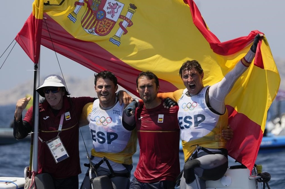 Florian Trittel Paul and Diego Botin Le Chever of Spain celebrate clinching the gold medal in the men's skiff race, at the 2024 Summer Olympics, Friday, Aug. 2, 2024, in Marseille, France. (AP Photo/Jacquelyn Martin)