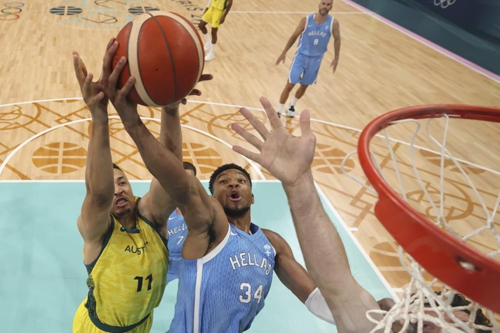 Giannis Antetokounmpo, of Greece, shoots in front of Dante Exum, of Australia, in a men's basketball game at the 2024 Summer Olympics, Friday, Aug. 2, 2024, in Villeneuve-d'Ascq, France. (Gregory Shamus/Pool Photo via AP)
