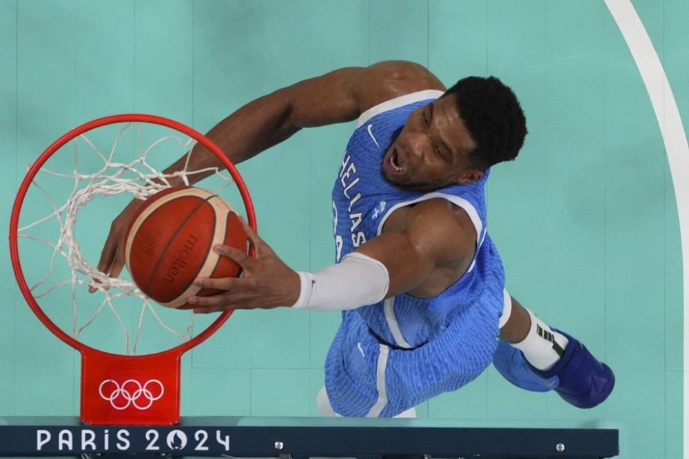 Giannis Antetokounmpo, of Greece, gets a basket on a dunk against Australia in a men's basketball game at the 2024 Summer Olympics, Friday, Aug. 2, 2024, in Villeneuve-d'Ascq, France. (Brian Snyder/Pool Photo via AP)