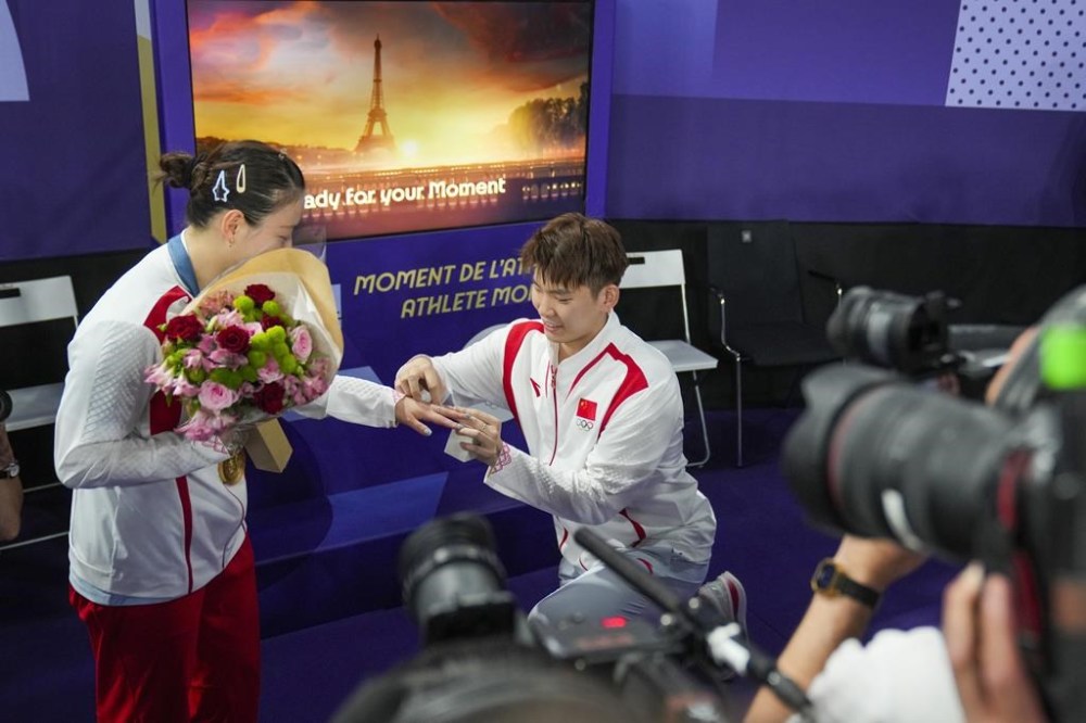China's Liu Yuchen proposes to teammate Huang Ya Qiong after she won her mixed doubles badminton final match at the 2024 Summer Olympics, Friday, Aug. 2, 2024, in Paris, France. (AP Photo/Dita Alangkara)