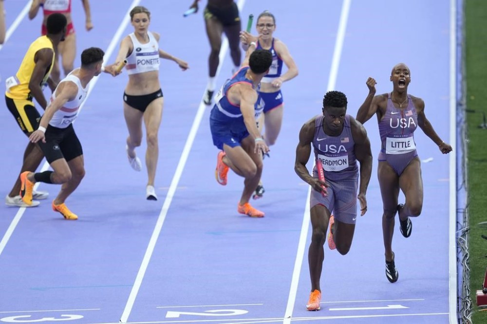 Shamier Little hands off to Bryce Deadmon, of the United States, during a heat in the 4 x 400-meter relay mixed at the 2024 Summer Olympics, Friday, Aug. 2, 2024, in Saint-Denis, France. (AP Photo/Martin Meissner)