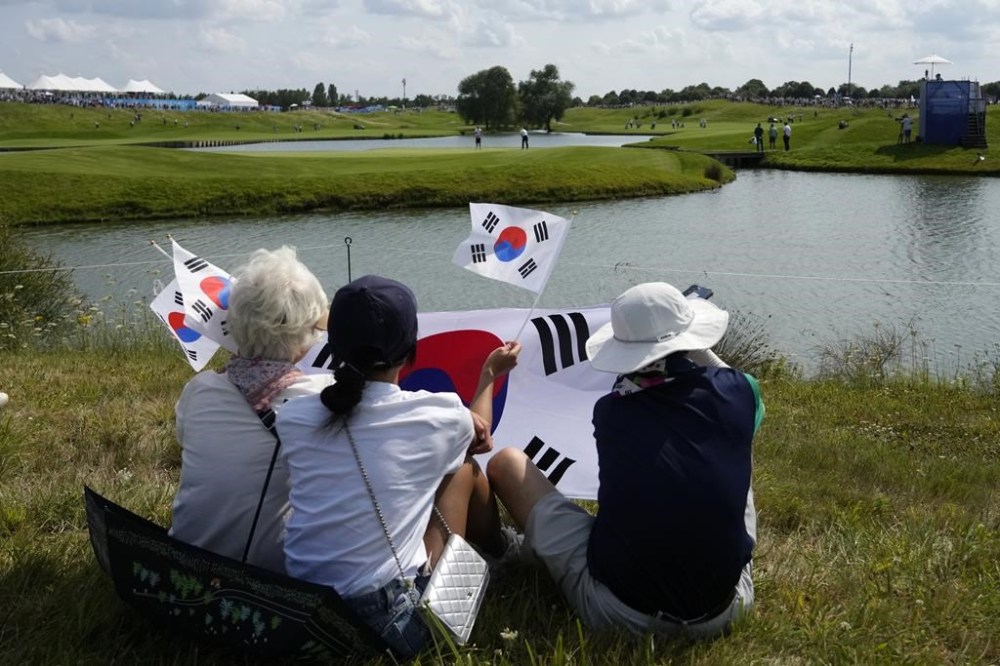 Korean fans watch Tom Kim, of South Korea, play the 15th Hoel during the second round of the men's golf event at the 2024 Summer Olympics, Friday, Aug. 2, 2024, at Le Golf National in Saint-Quentin-en-Yvelines, France. (AP Photo/Matt York)