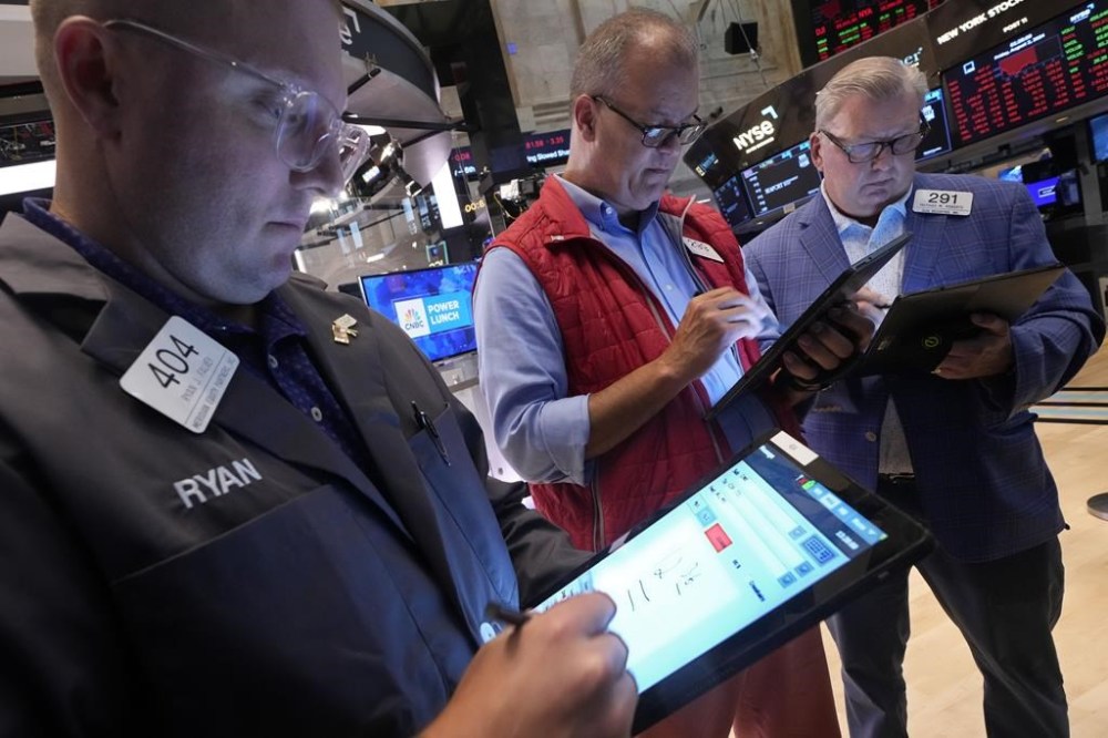 A trio of traders work on the floor of the New York Stock Exchange, Friday, Aug. 2, 2024. (AP Photo/Richard Drew)