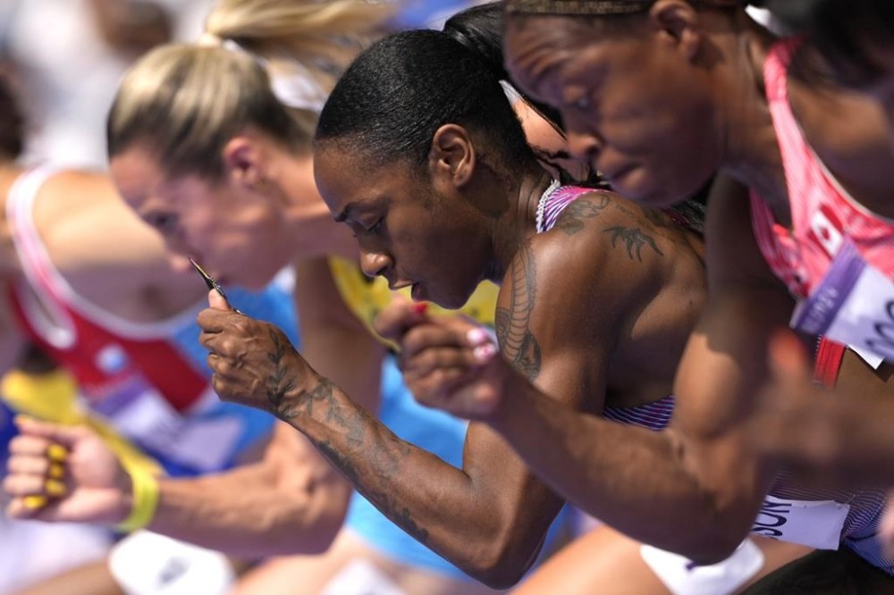 Sha'carri Richardson, of the United States, center, competes in her women's 100 meters round 1 heat at the 2024 Summer Olympics, Friday, Aug. 2, 2024, in Saint-Denis, France. (AP Photo/Bernat Armangue)