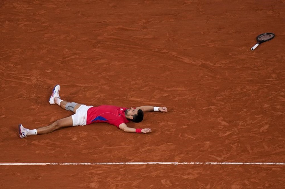 Novak Djokovic of Serbia celebrates after defeating Lorenzo Musetti of Italy in their men's singles semifinals tennis match, at the 2024 Summer Olympics, Friday, Aug. 2, 2024, at the Roland Garros stadium in Paris, France. (AP Photo/Manu Fernandez)