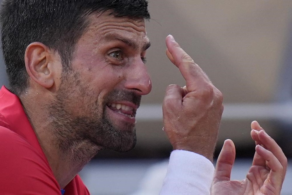 Novak Djokovic of Serbia reacts during a break as he plays against Lorenzo Musetti of Italy during their men's singles semifinals tennis match, at the 2024 Summer Olympics, Friday, Aug. 2, 2024, at the Roland Garros stadium in Paris, France. (AP Photo/Andy Wong)