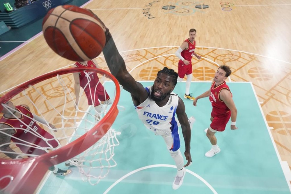 Mathias Lessort, of France, gets a dunk against Germany in a men's basketball game at the 2024 Summer Olympics, Friday, Aug. 2, 2024, in Villeneuve-d'Ascq, France. (AP Photo/Mark J. Terrill, Pool)