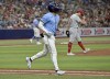 Tampa Bay Rays' Richie Palacios jogs to first base after walking in the go-ahead run from Cincinnati Reds reliever Lucas Sims, right, during the eighth inning of a baseball game, Sunday, July 28, 2024, in St. Petersburg, Fla. (AP Photo/Steve Nesius)
