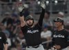 Miami Marlins' Jake Burger gestures to his teammates in the dugout after driving in a run with a base hit in the seventh inning of a baseball game against the Atlanta Braves, Thursday, Aug. 1, 2024, in Atlanta. (AP Photo/John Bazemore)
