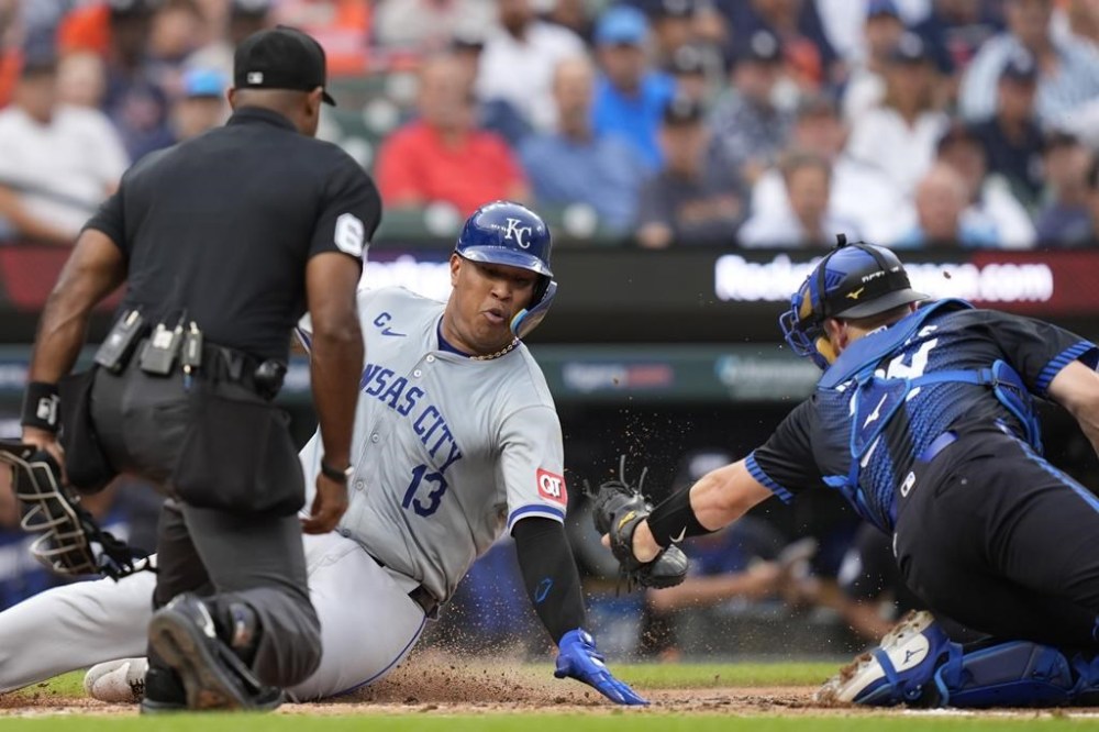 Kansas City Royals' Salvador Perez beats the throw to Detroit Tigers catcher Jake Rogers to score during the fourth inning of a baseball game, Friday, Aug. 2, 2024, in Detroit. (AP Photo/Carlos Osorio)
