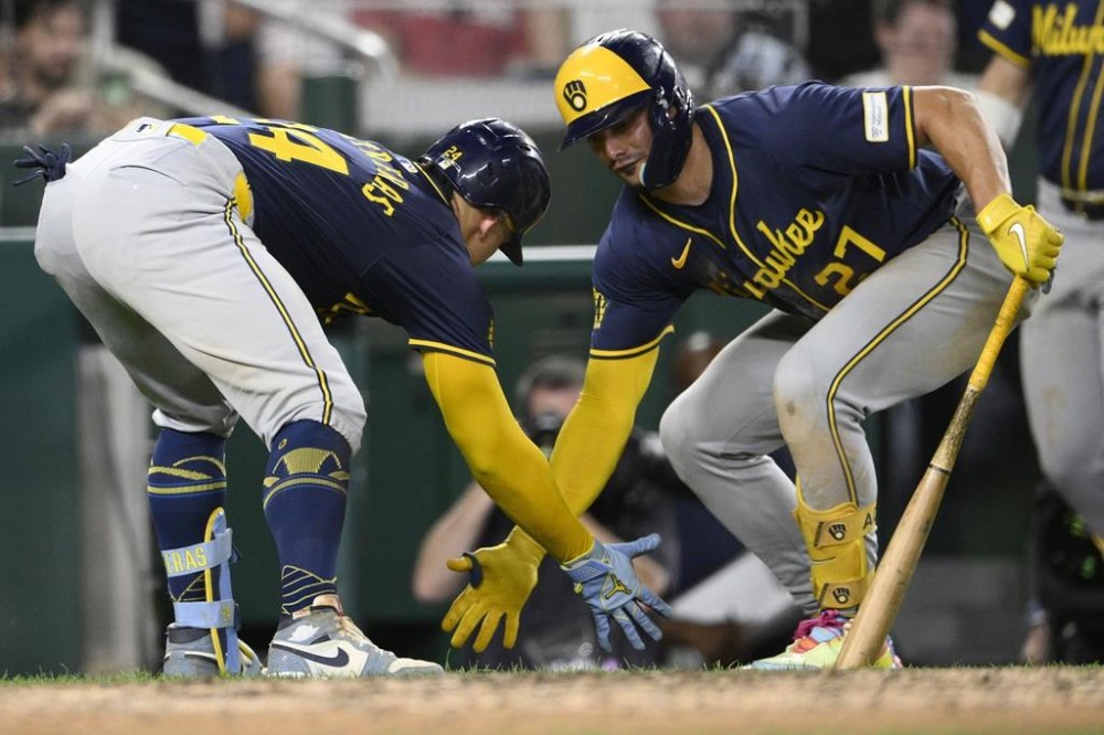 Milwaukee Brewers' William Contreras, left, celebrates after his home run with Willy Adames, right, during the seventh inning of a baseball game against the Washington Nationals, Friday, Aug. 2, 2024, in Washington. (AP Photo/Nick Wass)