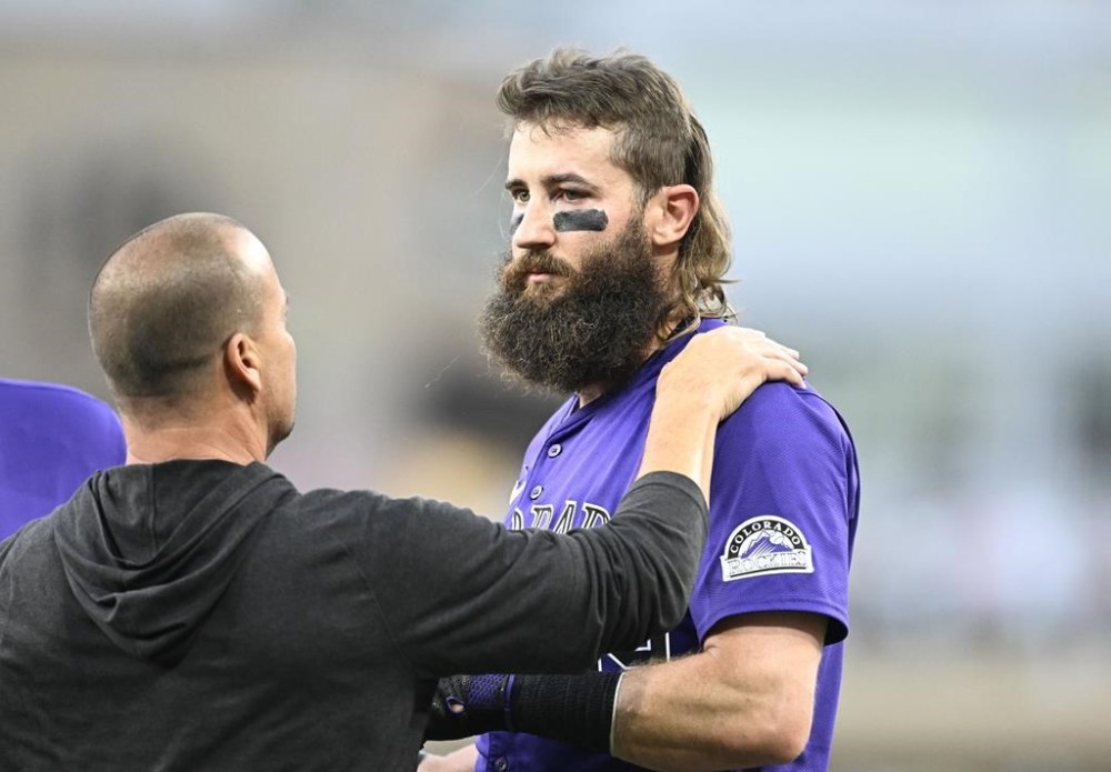 An unidentified trainer, left, looks at Colorado Rockies' Charlie Blackmon, right, after Blackmon was hit with a throw during the third inning of a baseball game against the San Diego Padres, Friday, Aug. 2, 2024, in San Diego. (AP Photo/Denis Poroy)