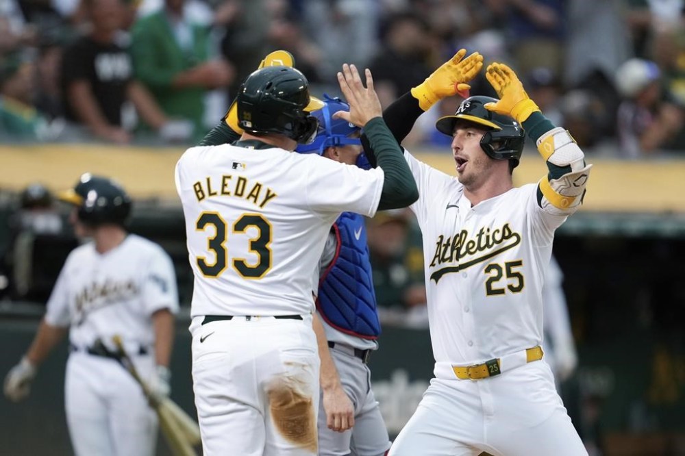 Oakland Athletics’ Brent Rooker, right, celebrates with JJ Bleday (33) after hitting a two-run home run against the Los Angeles Dodgers during the fifth inning of a baseball game Friday, Aug. 2, 2024, in Oakland, Calif. (AP Photo/Godofredo A. Vásquez)