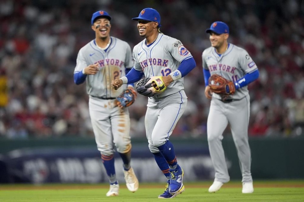 New York Mets shortstop Francisco Lindor, center, celebrates with third baseman Mark Vientos, left, and second baseman Jose Iglesias, right, after the final out of the fifth inning of a baseball game against the Los Angeles Angels, Friday, Aug. 2, 2024, in Anaheim, Calif. (AP Photo/Ryan Sun)
