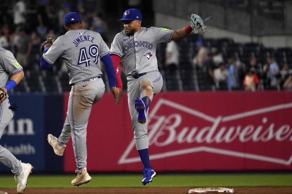 Toronto Blue Jays' Leo Jiménez, left, and Steward Berroa, right, celebrate after winning a baseball game against the New York Yankees, Friday, Aug. 2, 2024, in New York. (AP Photo/Pamela Smith)