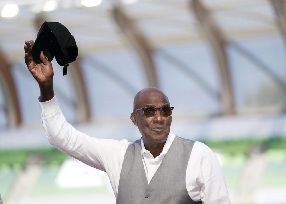 FILE - Bobby Kersee holds up his hat as he is honored as the 2023 USATF Legend Coach of the Year the during the U.S. track and field championships in Eugene, Ore., Saturday, July 8, 2023. Kersee's known as the “mad scientist” for his outside-the-box training methods. He's concocted a winning formula that’s struck gold for some of the biggest stars in track history. (AP Photo/Ashley Landis, File)