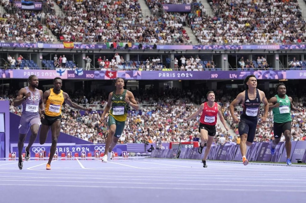 Louie Hinchliffe, of Britain, wins a heat in the men's 100-meter ahead of Noah Lyles, of the United States, at the 2024 Summer Olympics, Saturday, Aug. 3, 2024, in Saint-Denis, France. (AP Photo/David J. Phillip)