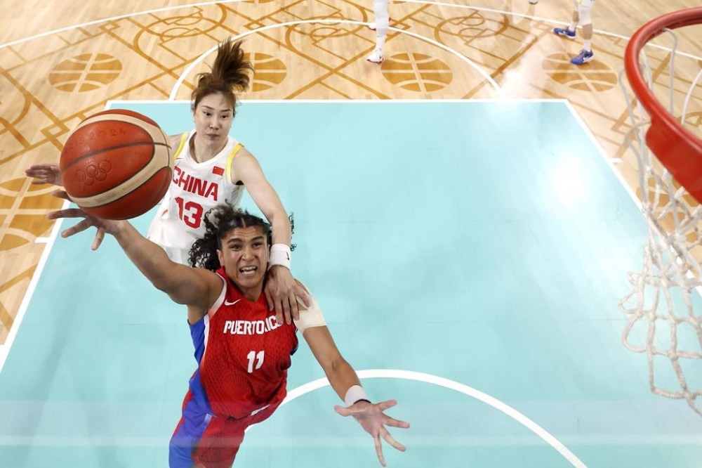 Puerto Rico's Sofia Roma, below, shoots as China's Sun Mengran defends during a basketball game at the 2024 Summer Olympics, Saturday, Aug. 3, 2024, in Villeneuve-d'Ascq, France. (Gregory Shamus/Pool Photo via AP)