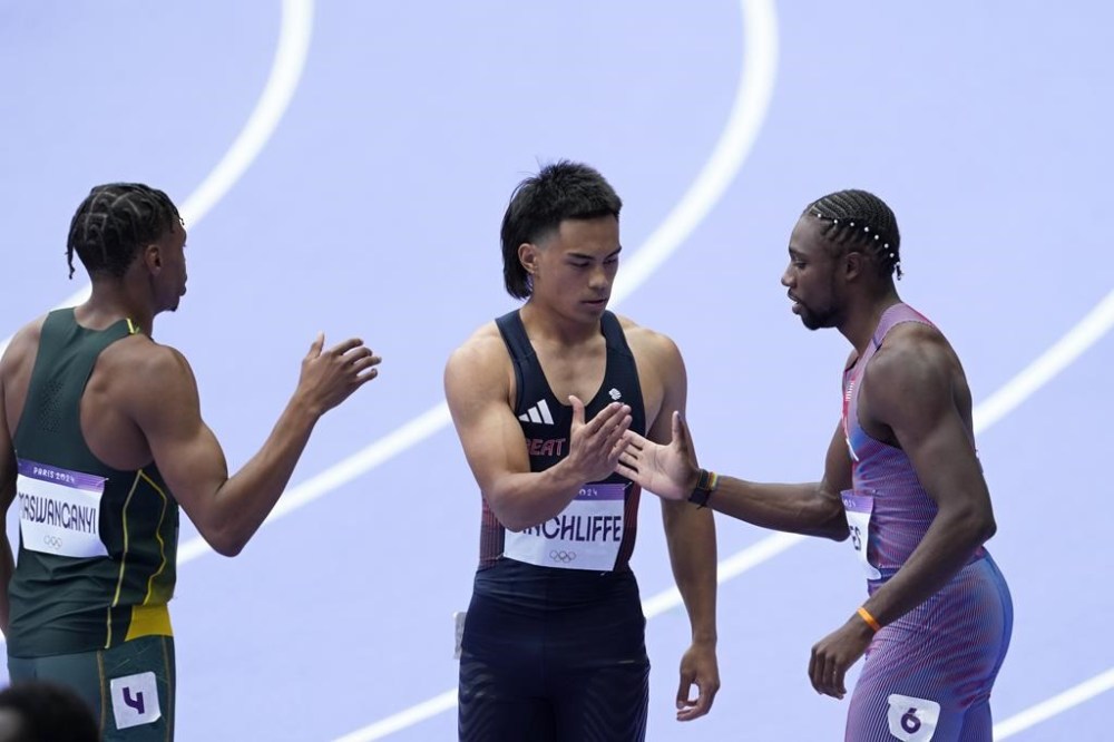 Noah Lyles, of the United States, right, Louie Hinchliffe, of Britain, and Shaun Maswanganyi, of South Africa, left, shake hands after qualifying in a men's 100 meters round 1 heat at the 2024 Summer Olympics, Saturday, Aug. 3, 2024, in Saint-Denis, France. (AP Photo/Martin Meissner)