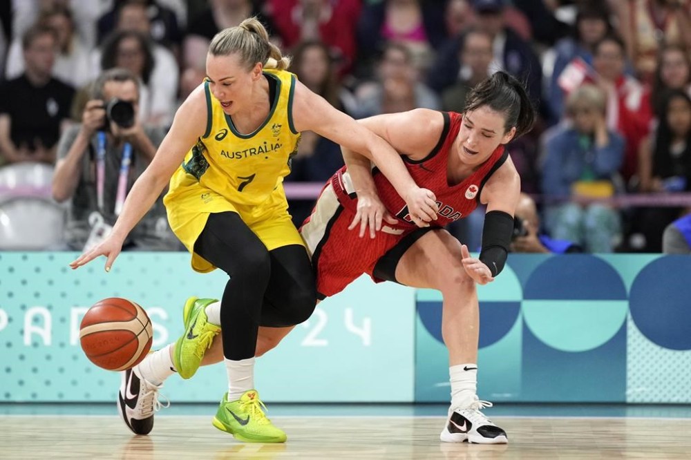 Australia's Tess Madgen dribbles while under pressure from Canada's Bridget Carleton during a women's basketball game at the 2024 Summer Olympics, Thursday, Aug. 1, 2024, in Villeneuve-d'Ascq, France. THE CANADIAN PRESS/AP-Michael Conroy