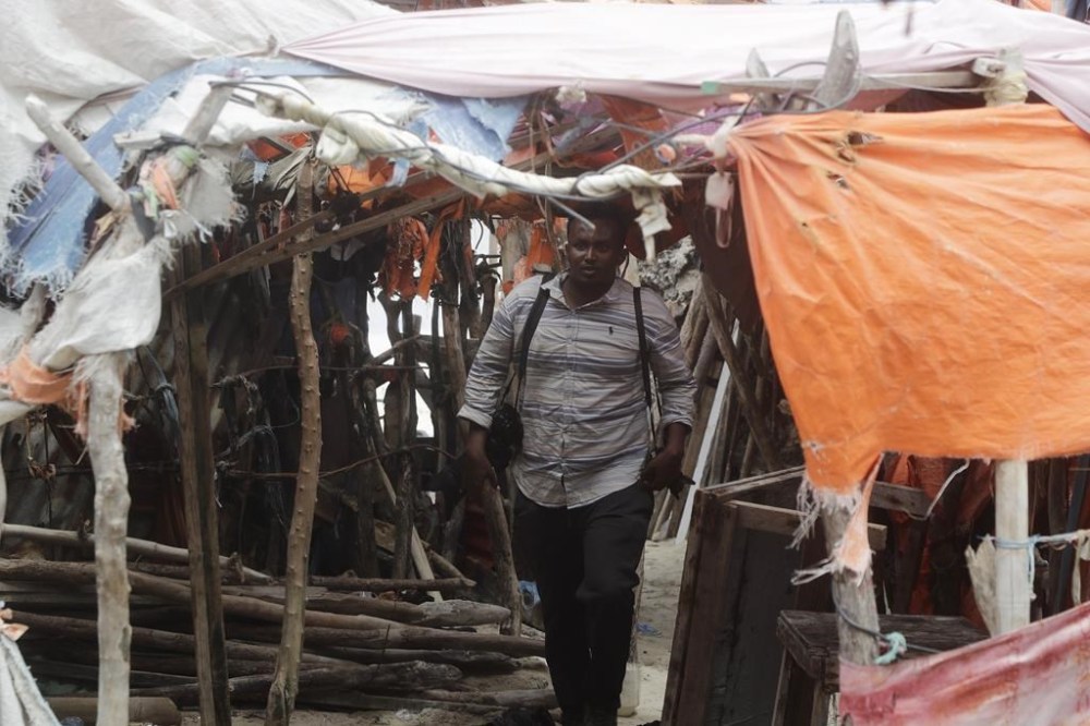A man walks out from makeshift houses on the beach, following an attack in Mogadishu, Somalia, Saturday Aug. 3, 2024. Police in Somalia said Saturday that many people died and several others were wounded in an attack on a beach hotel in the capital, Mogadishu, the previous evening. (AP Photo/Farah Abdi Warsameh)