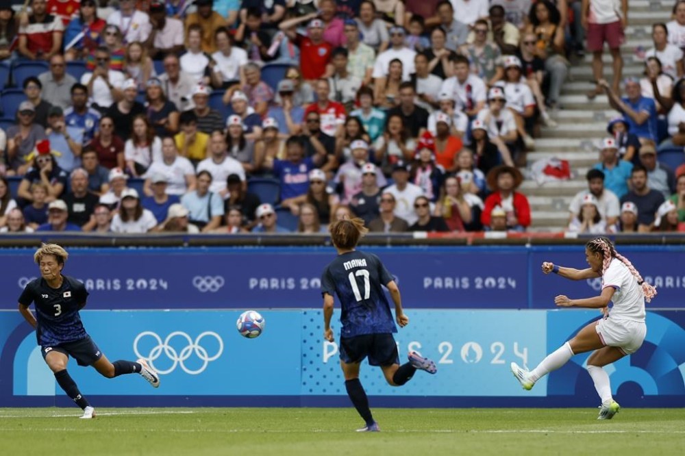 Trinity Rodman of the United States, right, scores the opening goal during the quarterfinal women's soccer match between the United States and the Japan at the Parc des Princes at the 2024 Summer Olympics, Saturday, Aug. 3, 2024, in Paris, France. (AP Photo/Aurelien Morissard)