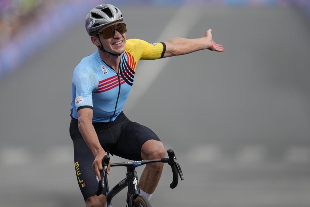 Remco Evenepoel, of Belgium, celebrates winning the men's road cycling event, at the 2024 Summer Olympics, Saturday, Aug. 3, 2024, in Paris, France. (AP Photo/Dar Yasin)