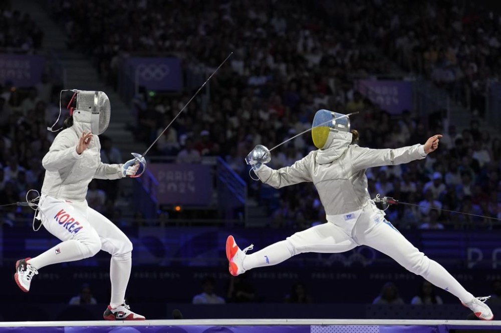 South Korea's Jeon Hayoung, left, competes with Ukraine's Alina Komashchuk in the women's team sabre final match during the 2024 Summer Olympics at the Grand Palais, Saturday, Aug. 3, 2024, in Paris, France. (AP Photo/Vadim Ghirda)