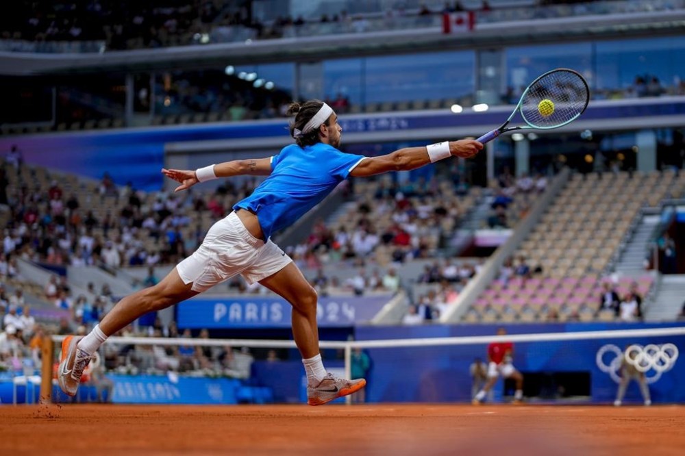 Lorenzo Musetti of Italy returns the ball against Felix Auger-Aliassime of Canada during men's singles bronze medal tennis match at the Roland Garros stadium, at the 2024 Summer Olympics, Saturday, Aug. 3, 2024, in Paris, France. (AP Photo/Manu Fernandez)