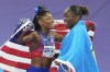 Gold medal winner Julien Alfred, of Saint Lucia, right, celebrates along with bronze medalist Melissa Jefferson, of the United States, after winning the women's 100-meter final at the 2024 Summer Olympics, Saturday, Aug. 3, 2024, in Saint-Denis, France. (AP Photo/Rebecca Blackwell)