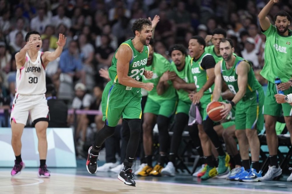 Raul Neto, of Brazil, celebrates after forcing a turnover on Keisei Tominaga, of Japan, in a men's basketball game at the 2024 Summer Olympics, Friday, Aug. 2, 2024, in Villeneuve-d'Ascq, France. (AP Photo/Mark J. Terrill)